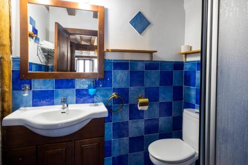a blue tiled bathroom with a sink and a toilet at Zadorra Etxea Casa in Salvatierra
