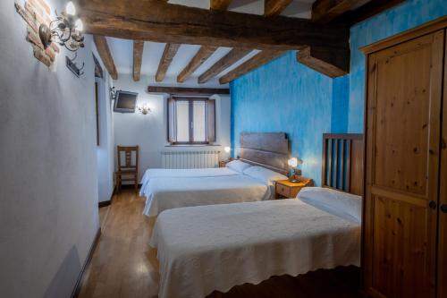 a bedroom with two beds and blue walls at Zadorra Etxea Casa in Salvatierra