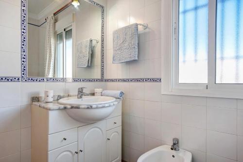 a bathroom with a sink and a mirror and a toilet at Las Calas de Roche in Roche