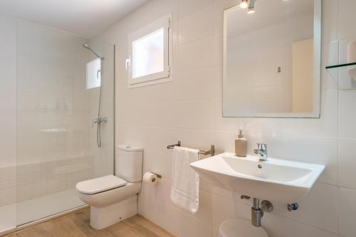 a white bathroom with a sink and a toilet at Can Botana 12 in Cala de Sant Vicenc