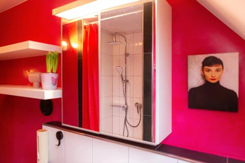 a bathroom with a shower and a picture of a man at s'Krumme Gustels Hüs in Bahlingen