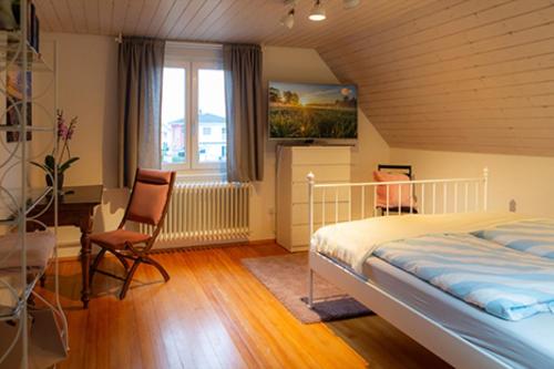 a bedroom with a bed and a desk and a window at s'Krumme Gustels Hüs in Bahlingen