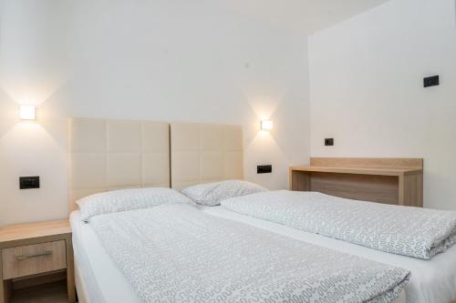 a bedroom with two beds and two lights on the wall at Il Mondo di Patty 3 in Pera