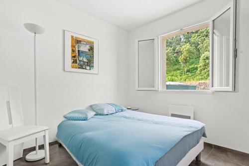 a white bedroom with a bed and a window at Villa les Coteaux du soleil in Carcès