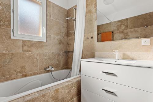 a bathroom with a sink and a bathtub and a mirror at Villa les Coteaux du soleil in Carcès