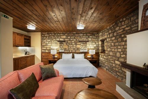 a bedroom with a bed and a couch in a room at Guest House Amadryades in Karpenisi