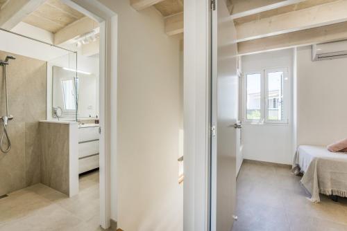a bathroom with a shower and a bed in a room at Els Arbocers 131-2 in Cala Blanca