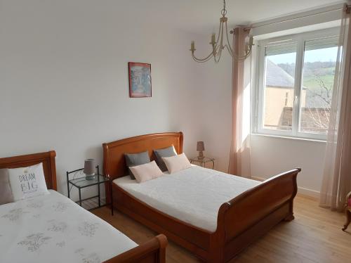 a bedroom with two beds and a window at Gîte des Bruyeres in Beynat
