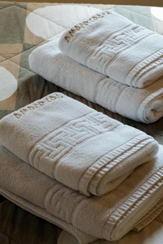 two folded towels sitting on top of a bed at Guest House Amadryades in Karpenisi