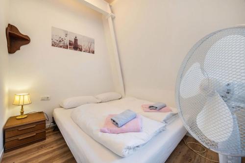 a room with a white bed with a fan at Die Alter Schwede Wohnung 3 in Vechta