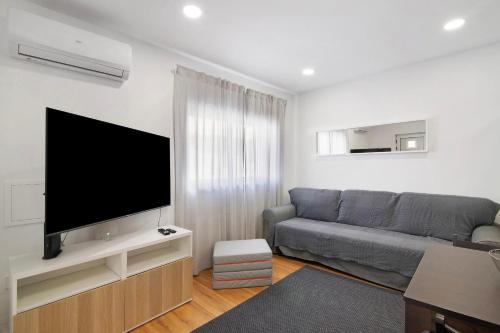 a living room with a couch and a flat screen tv at Telmus Villa Rc E in Monte Gordo