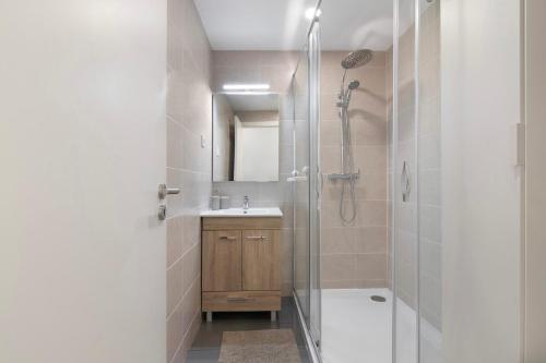 a bathroom with a shower and a sink and a mirror at Telmus Villa Rc E in Monte Gordo