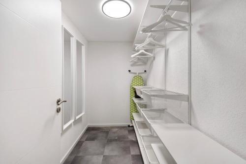 a walk in closet with glass shelves and a door at Modern und gemütlich- in Teningen in Teningen