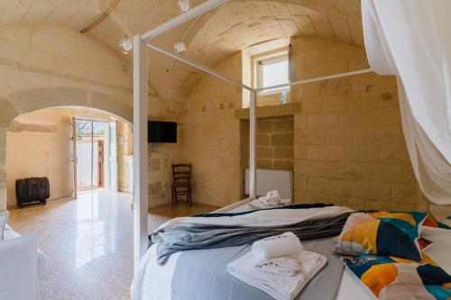 a bedroom with two beds in a stone wall at Corte Cochlea Lu Sciardinu Suite in Cannole