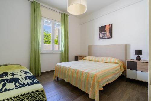 a bedroom with two beds and a window at Di Chiara in Torre Lapillo