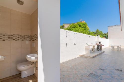 a bathroom with a toilet and a white wall at Di Chiara in Torre Lapillo