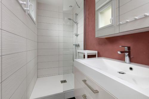 a white bathroom with a sink and a shower at Maison et Bonheur in Batz-sur-Mer