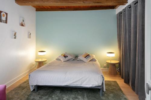 a bedroom with a white bed with two lamps at Maison et Bonheur in Batz-sur-Mer