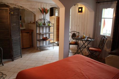 a bedroom with a bed and a table in a room at La chambre L'ile de Tom in Lège-Cap-Ferret