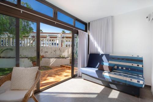 a living room with a blue couch and a balcony at Casa Relax Marine in Costa Del Silencio