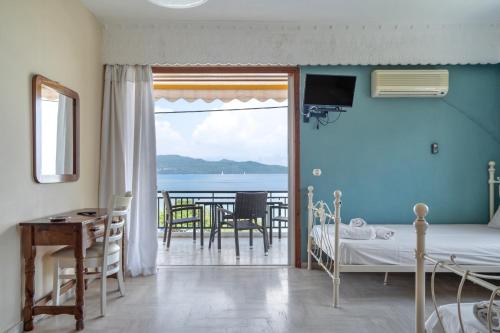 a room with a bedroom with a view of the ocean at Giorgio studios-apartments 2 in Nikiana