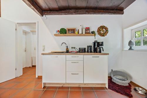 a kitchen with white cabinets and a sink at Wie Bei Muddi in Lübbecke
