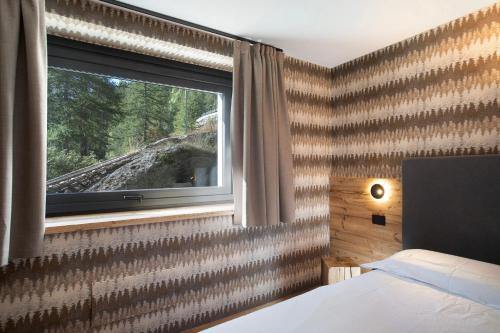 a bedroom with a window with a view of a train at Valgrisa Mountain Lodges 2 in Valgrisenche