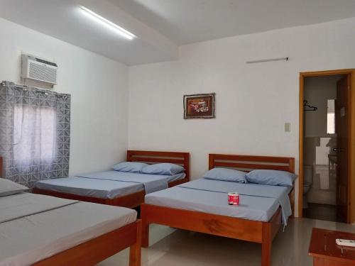 a room with three beds and a window at Sea Breeze Beach Resort in Pagudpud