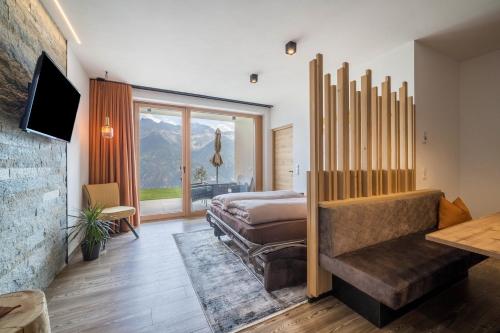 a bedroom with a bed and a large window at Paflur Lodges Bergtraum in Lasa