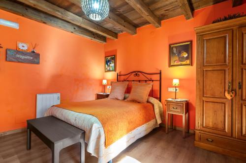 a bedroom with orange walls and a bed in it at Nogueira in Vega de Logares