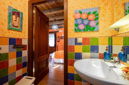 a bathroom with a sink and colorful tiles at Nogueira in Vega de Logares