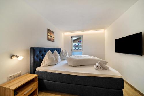 a bedroom with a bed and a tv on a wall at Ferienwohnung Lamm 2 in San Valentino alla Muta