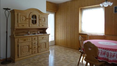 a kitchen with a wooden cabinet and a table at La Capinera Canazei Apartments in Canazei