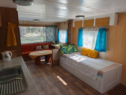 a bedroom with a bed and a desk in a boat at Horyna - Camp Pod kastany in Morávka
