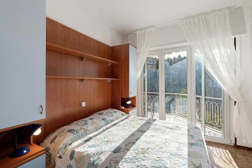 a bedroom with a bed and a large window at Casa Alizia in Ospedaletti