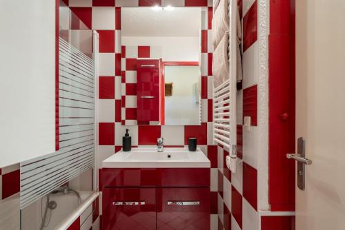 a red and white bathroom with a sink and a mirror at Métamorphose Au Sommet in Villard-de-Lans