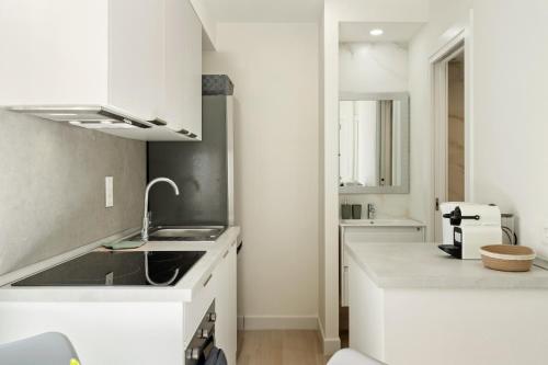 a white kitchen with a sink and a counter at Cala Luna-few steps from the beach in La Cala de Mijas
