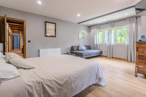a bedroom with a large bed and a chair at Cal Manyà in Susqueda