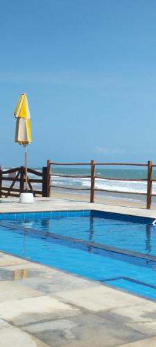 a swimming pool with the ocean in the background at Casa Amarela - Guajiru in Trairi