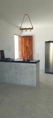 a kitchen with a counter and a sink in a room at Casa Amarela - Guajiru in Trairi