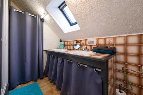 a bathroom with a sink and blue shower curtains at Logement Rieux À 6 Km De Redon in Rieux