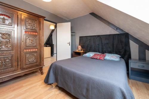 a bedroom with a bed and a large wooden cabinet at Logement Rieux À 6 Km De Redon in Rieux