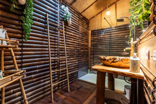 a bathroom with a sink and a wooden wall at Chalet Bangli in Lacanau