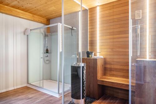a glass shower in a bathroom with wooden walls at Moselbude Cube mit Sauna in Traben-Trarbach
