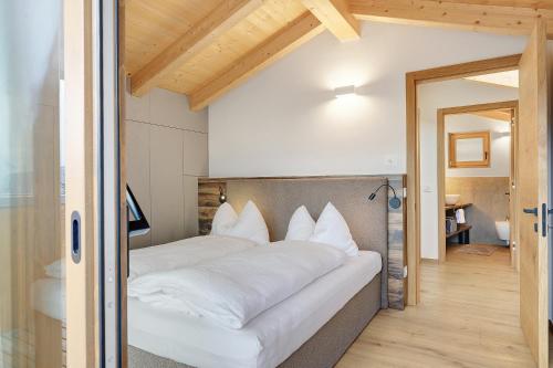 a bedroom with a large bed with white pillows at Rostrini Family Home Retreat in Cavalese