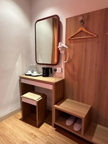 a bathroom with a vanity with a mirror and a sink at Lovina Inn - Nagoya Batam in Nagoya