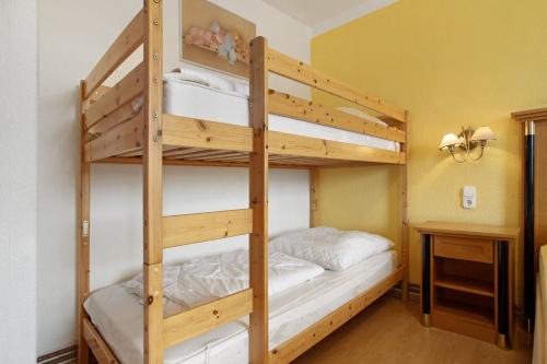 a bunk bed room with two bunk beds and a desk at Ferienwohnung oberhalb vom Hafen 1 in Sassnitz