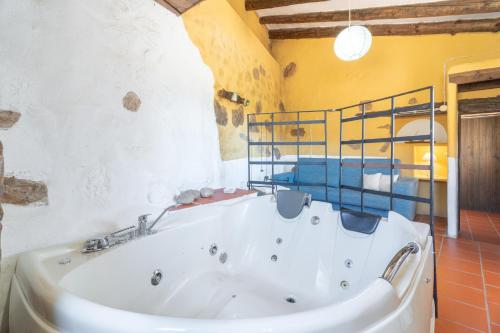 a large white tub in a bathroom with yellow walls at El Cup in La Torre d'En Besora