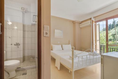 a bedroom with a bed and a shower and a toilet at Giorgio studios-apartments 2 in Nikiana