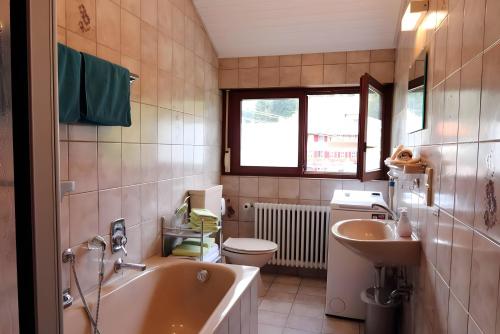 a bathroom with a tub and a toilet and a sink at Gasthaus Zur Linde Ferienwohnungen in Oberharmersbach